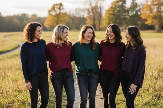 Group of 5 women standing in a field wearing dark colored clothing